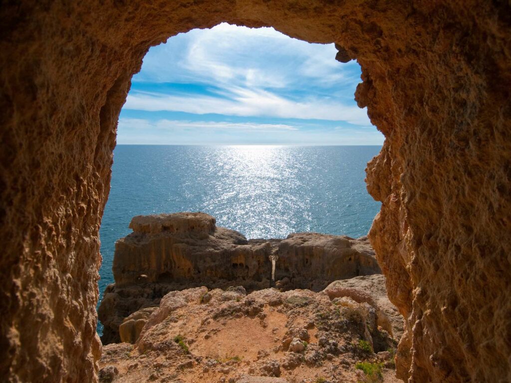 Que faire et voir en Algarve au Portugal :  Tunnel creusé dans la falaise menant à une plage secrète de l’Algarve